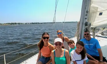 Happy family on bow of sailboat