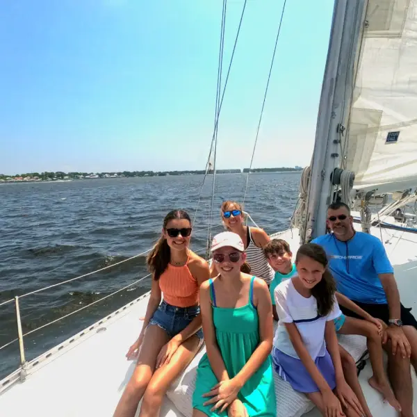 Happy family on bow of sailboat